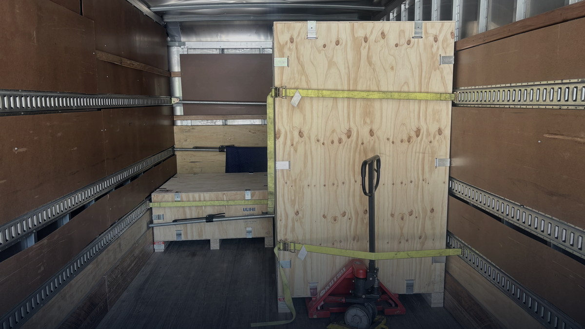 Strapped, crated freight inside a Sultan Freight box truck — a brokered load moving under the 2026 broker transparency rule
