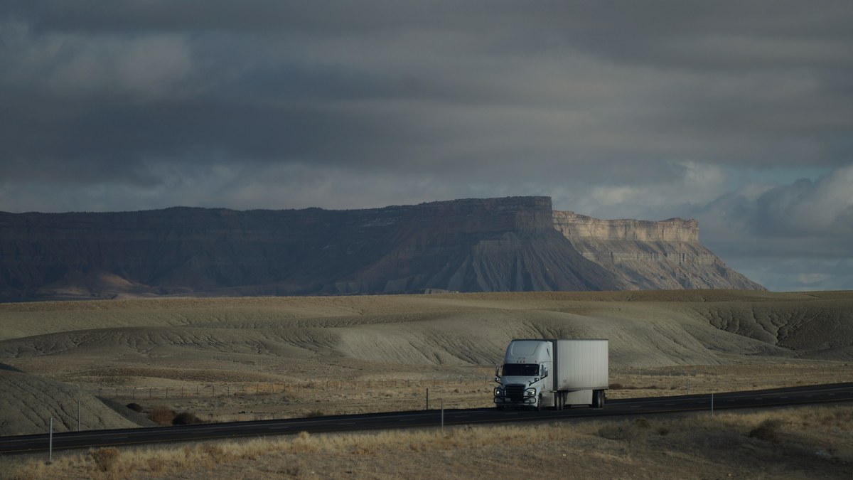Diesel fuel surcharge lag 2026: long-haul truck running interstate miles as diesel climbs to $5.454 a gallon
