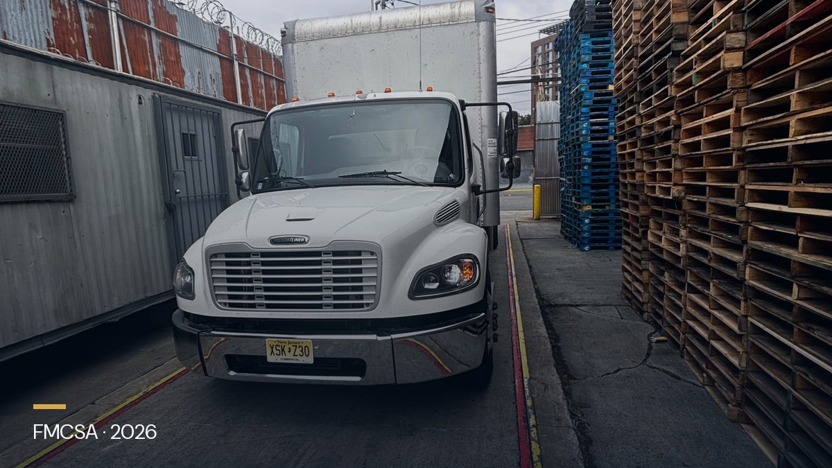 Freightliner box truck at a Northeast terminal with FMCSA inspection paperwork